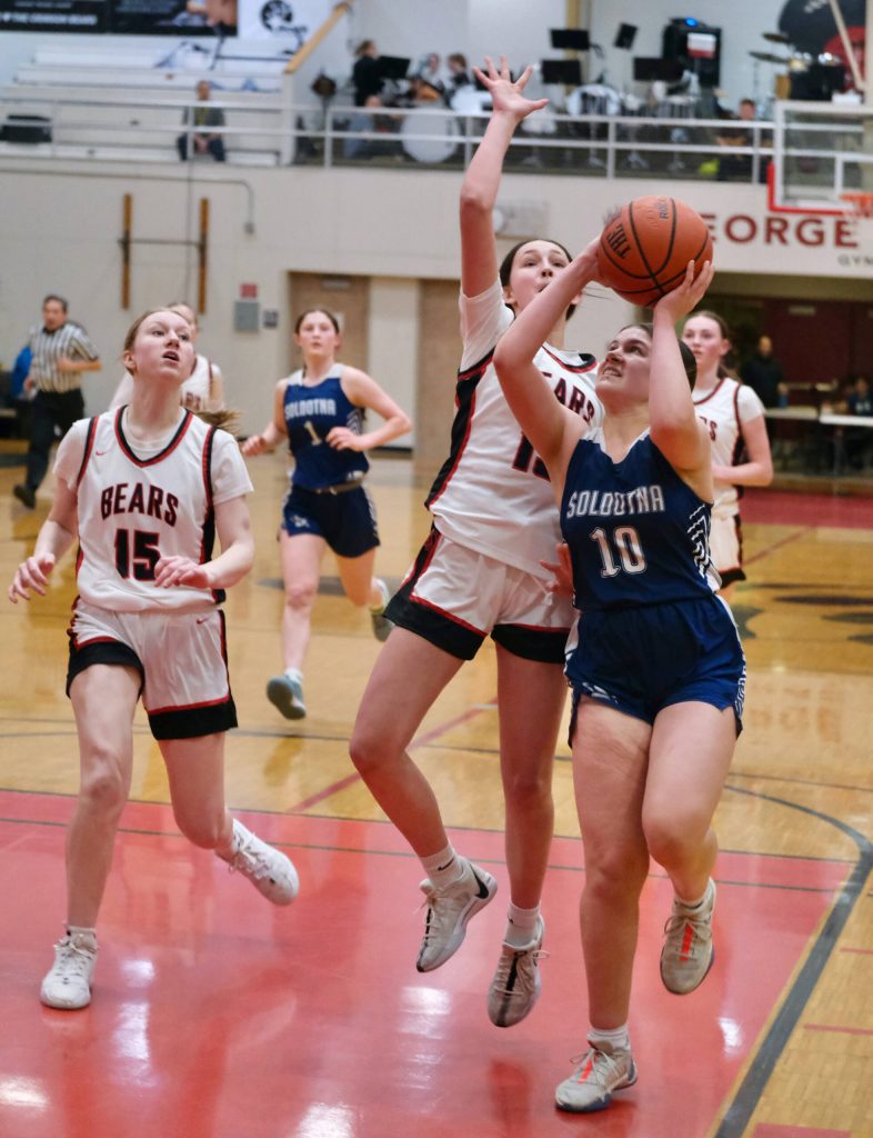 Juneau-Douglas High School: Yadaa.at Kalé freshman Sadie Lockhart (13) defends Soldotna junior Laurel Johnson (10) during the Crimson Bears 65-28 win over the Stars on Friday at the George Houston Gymnasium. JDHS freshman Lydia Goins (15) moves in on the play. (Klas Stolpe / Juneau Empire)