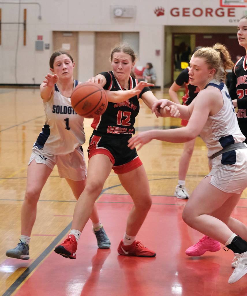 Juneau-Douglas High School: Yadaa.at Kalé sophomore Bergen Erickson (12) battles for a loose ball with Soldotna sophomore Teagen Kobylarz (1) and senior Hope Hillyer during the Crimson Bears 63-26 win over the Stars on Saturday at the George Houston Gymnasium. (Klas Stolpe / Juneau Empire)