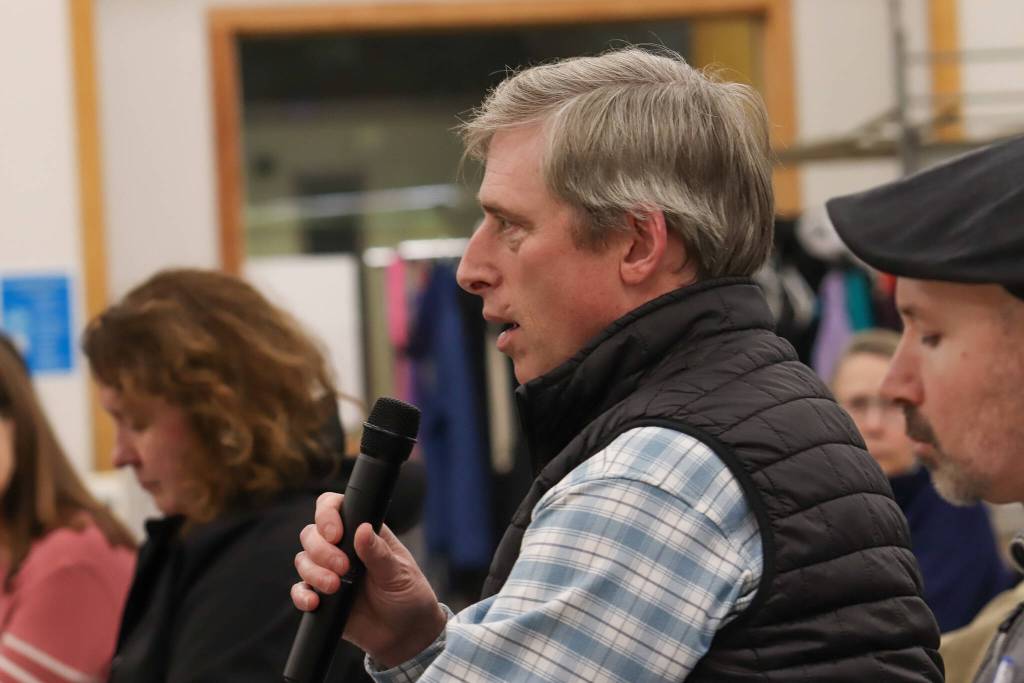 Aaron Brakel asks a question to the Juneau delegation during a town hall in the Dzantiki Heeni school commons on Monday, Jan. 13, 2025. (Jasz Garrett / Juneau Empire)