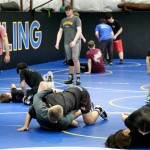 Askren Wrestling Academy coach Wilder Wichman watches as grapplers work techniques on Monday during a three-day wrestling clinic at the Juneau Wrestling Center. (Klas Stolpe / Juneau Empire)