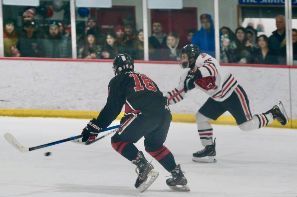 Juneau-Douglas High School: Yadaa.at Kalé senior Dylan Sowa (35) puts a shot past Kenai defender Sawyer Vann (18) during the Crimson Bears 5-4 loss to the Kardinals Friday at Treadwell Ice Arena. The teams play Saturday at 8:30 a.m. (Klas Stolpe / Juneau Empire)