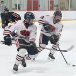 Juneau-Douglas High School: Yadaa.at Kalé seniors Zander Smith (8) and Loren Platt (26) control a puck during the Crimson Bears 5-4 loss to the Kardinals Friday at Treadwell Ice Arena. The teams play Saturday at 8:30 a.m. (Klas Stolpe / Juneau Empire)