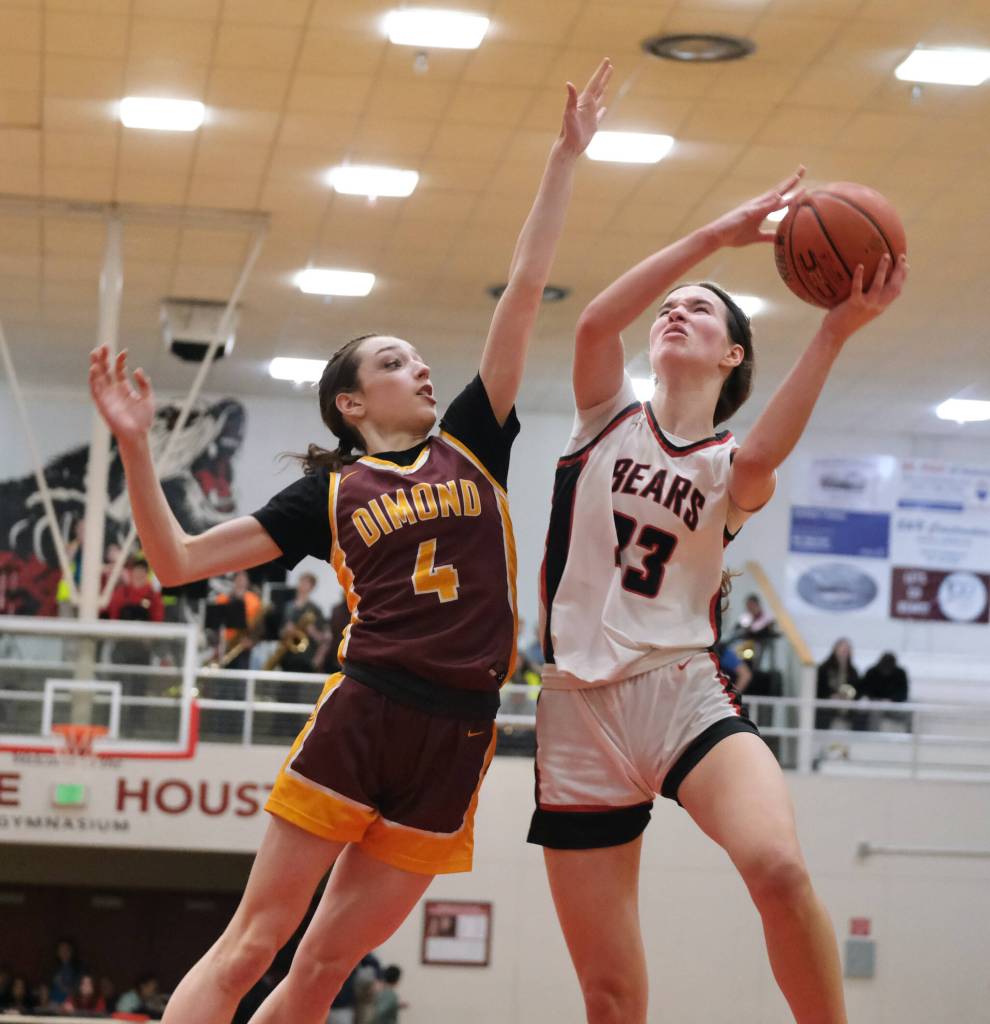 Dimond junior Sophie Scott (4) defends a shot by Juneau-Douglas High School: Yadaa.at Kalé senior Cailynn Baxter (23) during Fridays JDHS Crimson Bears 62-48 win over the visiting Lynx inside the George Houston Gymnasium. The teams play Saturday at 7 p.m. (Klas Stolpe / Juneau Empire)