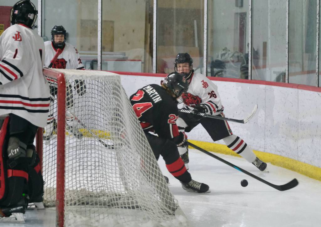 Juneau-Douglas High School: Yadaa.at Kalé senior Loren Platt (26) defends Kenais Avery Martin (24) during the Crimson Bears 5-1 loss to the Kardinals Saturday at Treadwell Ice Arena. (Klas Stolpe / Juneau Empire)
