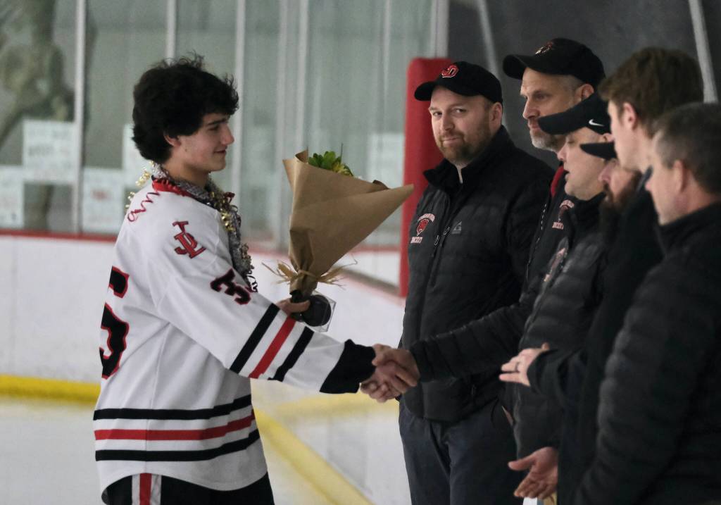 Juneau-Douglas High School: Yadaa.at Kalé senior Dylan Sowa shakes hands with coaches during ceremonies before the Crimson Bears game Friday against the visiting Kenai Kardinals at Treadwell Ice Arena. (Klas Stolpe / Juneau Empire)