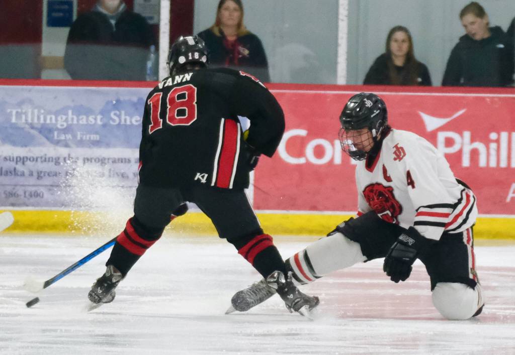 Juneau-Douglas High School: Yadaa.at Kalé senior Luke Bovitz (4) stops a shot by Kenais Sawyer Vann, despite losing his stick, during the Crimson Bears 5-1 loss to the Kardinals on Saturday at Treadwell Ice Arena. (Klas Stolpe / Juneau Empire)