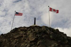 A marker for the U.S.-Canadian border sits between Skagway, Alaska, and Stikine Region, British Columbia. (Philip Yabut/Getty Images)
