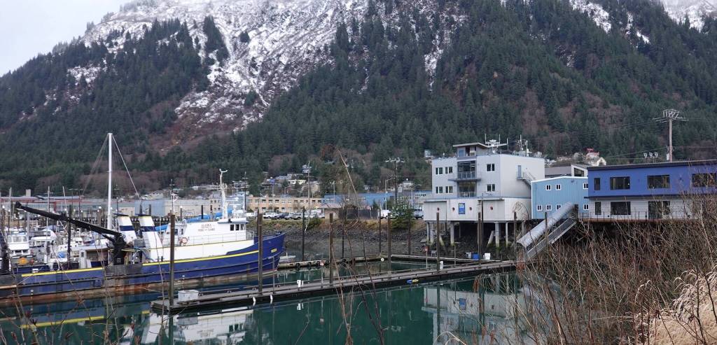The gray MXAK building stands on the shoreline above Harris Harbor where fishing and pleasure boats dock near the Alaska Department of Fish and Games vessel Medeia. (Laurie Craig / Juneau Empire)