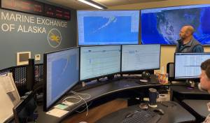 MXAKs executive director Steve White watches the wall of monitoring screens as maritime information specialist Jason Hort (foreground) tracks vessels transiting the North Pacific. (Laurie Craig / Juneau Empire)