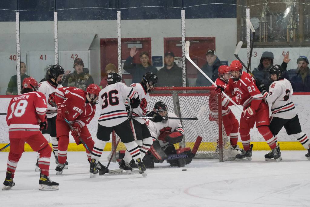 Juneau-Douglas High School: Yadaa.at Kalé senior goalie Caleb Friend keeps the puck out of the net during the Crimson Bears 3-1 win over the Warriors at Treadwell Ice Arena on Saturday. (Klas Stolpe / Juneau Empire)