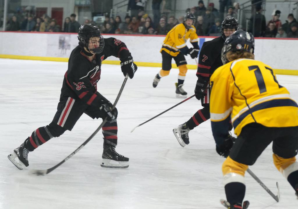 Juneau-Douglas High School: Yadaa.at Kalé senior Dylan Sowa (35) shoots against Tri-Valley during the Crimson Bears 4-2 loss to the Warriors at Treadwell Ice Arena on Saturday. (Klas Stolpe / Juneau Empire)