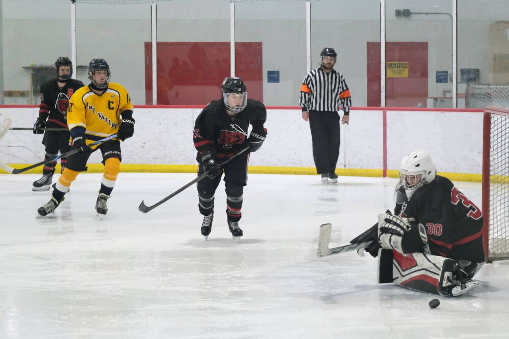 Juneau-Douglas High School: Yadaa.at Kalé sophomore goalie Taylor Petrie (30) deflects a Tri-Valley shot during the Crimson Bears 4-2 loss to the Warriors at Treadwell Ice Arena on Saturday. (Klas Stolpe / Juneau Empire)