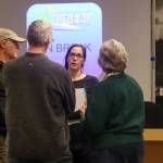 Elizabeth Figus speaks with others who testified at a Juneau Assembly meeting after a motion passed to install temporary flood barriers on Feb. 3, 2025. (Jasz Garrett / Juneau Empire)