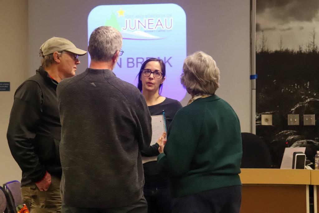 Elizabeth Figus speaks with others who testified at a Juneau Assembly meeting after a motion passed to install temporary flood barriers on Feb. 3, 2025. (Jasz Garrett / Juneau Empire)