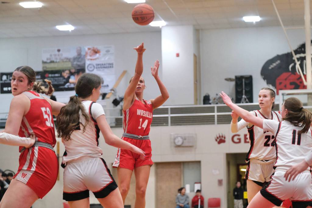 Wasilla senior Mylee Anderson (14) scores over Juneau-Douglas High School: Yadaa.at Kalé defenders during the Warriors 65-34 win over the Crimson Bears on Friday in the George Houston Gymnasium. (Klas Stolpe / Juneau Empire)
