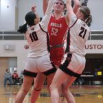 Wasilla senior Layla Hays (52) scores over Juneau-Douglas High School: Yadaa.at Kalé senior Addison Wilson (10) and freshman Athena Warr (21) during the Warriors 65-34 win over the Crimson Bears on Friday in the George Houston Gymnasium. (Klas Stolpe / Juneau Empire)