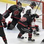 Kenai Centrals Sawyer Vann and Elliot Welch of Juneau-Douglas battle for the puck in front of Juneau goalie Caleb Friend at the First National Cup Division II state hockey tournament Saturday at the Soldotna Regional Sports Complex in Soldotna. (Jeff Helminiak/Peninsula Clarion)