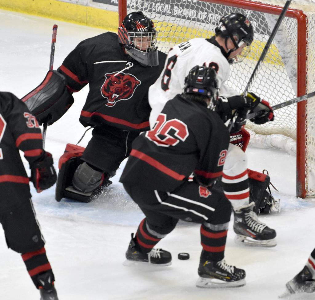 Kenai Centrals Sawyer Vann and Elliot Welch of Juneau-Douglas battle for the puck in front of Juneau goalie Caleb Friend at the First National Cup Division II state hockey tournament Saturday at the Soldotna Regional Sports Complex in Soldotna. (Jeff Helminiak/Peninsula Clarion)