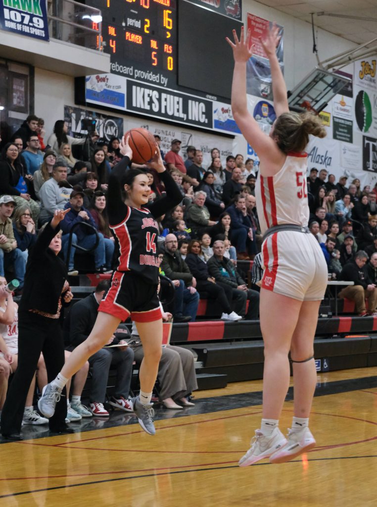 Juneau-Douglas High School: Yadaa.at Kalé sophomore Layla Tokuoka (14) jumps to pass over Wasilla senior Layla Hays (52) during the Crimson Bears 46-30 loss Saturday to the Warriors in the George Houston Gymnasium. (Klas Stolpe / Juneau Empire)