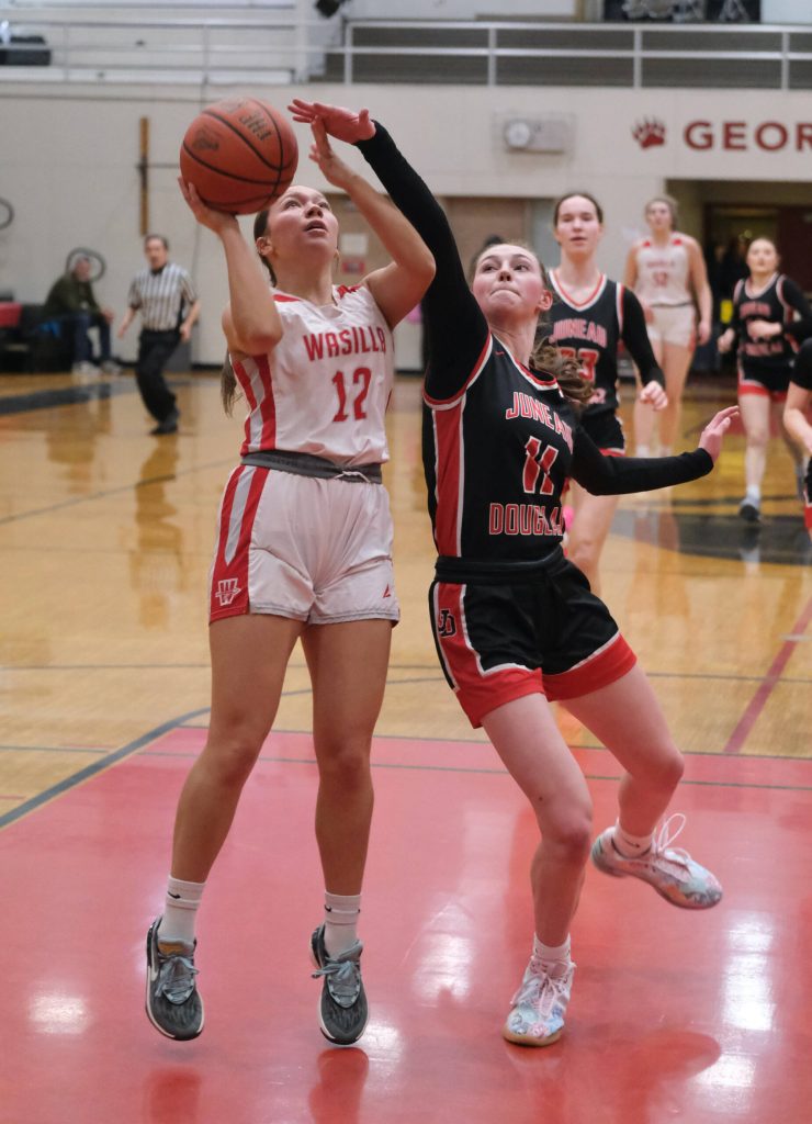 Juneau-Douglas High School: Yadaa.at Kalé junior Gwen Nizich defends a shot by and Wasilla junior Kinley Lynch (12) during the Crimson Bears 46-30 loss Saturday to the Warriors in the George Houston Gymnasium. (Klas Stolpe / Juneau Empire)
