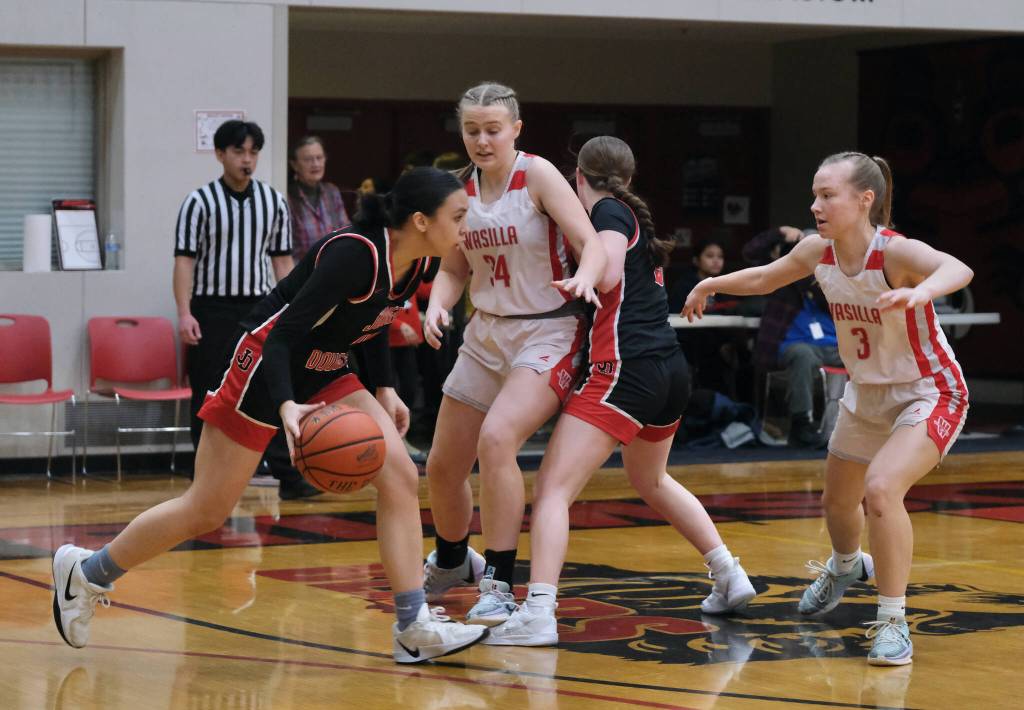 Juneau-Douglas High School: Yadaa.at Kalé senior Addison Wilson dribbles over a screen by junior Cambry Lockhart under pressure from Wasilla juniors Claire Bredberg (34) and Kinley Bruno (3) during the Crimson Bears 46-30 loss Saturday to the Warriors in the George Houston Gymnasium. (Klas Stolpe / Juneau Empire)
