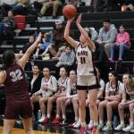 Juneau-Douglas High School: Yadaa.at Kalé junior Gwen Nizich (11) shoots from past the arc over Ketchikan junior Kylie Brendible (32) during the Crimson Bears 52-23 win over the Lady Kings on Thursday in Juneau. (Klas Stolpe / Juneau Empire)