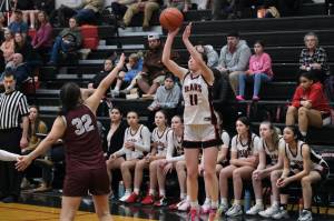Juneau-Douglas High School: Yadaa.at Kalé junior Gwen Nizich (11) shoots from past the arc over Ketchikan junior Kylie Brendible (32) during the Crimson Bears 52-23 win over the Lady Kings on Thursday in Juneau. (Klas Stolpe / Juneau Empire)