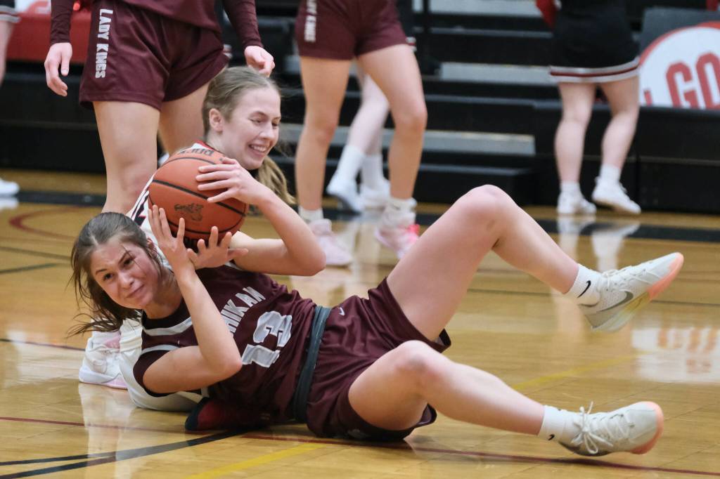 Ketchikan senior Aspen Bauer (13) battles for a loose ball with Juneau-Douglas High School: Yadaa.at Kalé sophomore Bergen Erickson during the Lady Kings 52-23 loss to the Crimson Bears on Thursday in Juneau. (Klas Stolpe / Juneau Empire)