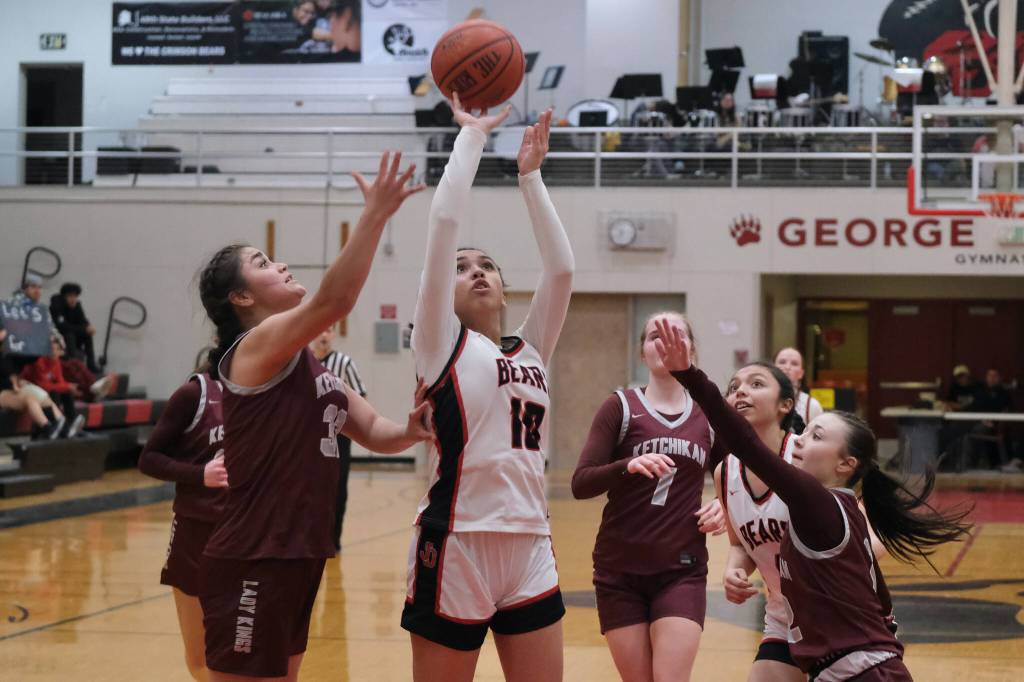 Juneau-Douglas High School: Yadaa.at Kalé senior Addison Wilson (10) shoots under pressure from Ketchikan junior Kylie Brendible (32) and freshman Peyton Nickich (2) during the Crimson Bears 52-23 win over the Lady Kings on Thursday in Juneau. (Klas Stolpe / Juneau Empire)