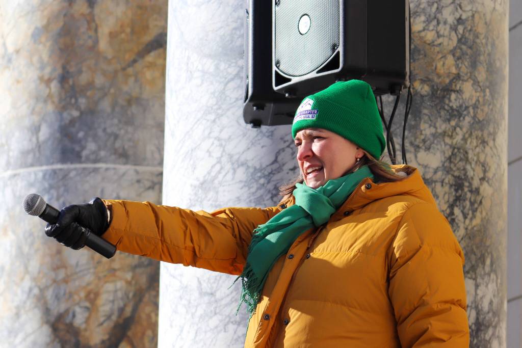 Heidi Drygas, executive director of the Alaska State Employees Association, leads a cheer on the steps of the Alaska State Capitol on Friday, Feb. 14, 2025. (Jasz Garrett / Juneau Empire)