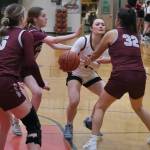 Juneau-Douglas High School: Yadaa.at Kalé sophomore Layla Tokuoka (14) threads a pass through Ketchikan senior Shyla Abajian (5), junior Lauren Tucker (11) and junior Kylie Brendible (32) during the Crimson Bears 51-23 win over the Lady Kings on Friday in Juneau. (Klas Stolpe / Juneau Empire)