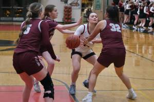 Juneau-Douglas High School: Yadaa.at Kalé sophomore Layla Tokuoka (14) threads a pass through Ketchikan senior Shyla Abajian (5), junior Lauren Tucker (11) and junior Kylie Brendible (32) during the Crimson Bears 51-23 win over the Lady Kings on Friday in Juneau. (Klas Stolpe / Juneau Empire)