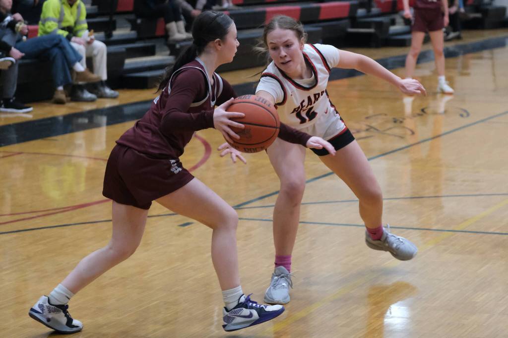 Juneau-Douglas High School: Yadaa.at Kalé sophomore Bergen Erickson (12) attempts to steal a dribble from Ketchikan freshman Peyton Nickich during the Crimson Bears 51-23 win over the Lady Kings on Friday in Juneau. (Klas Stolpe / Juneau Empire)