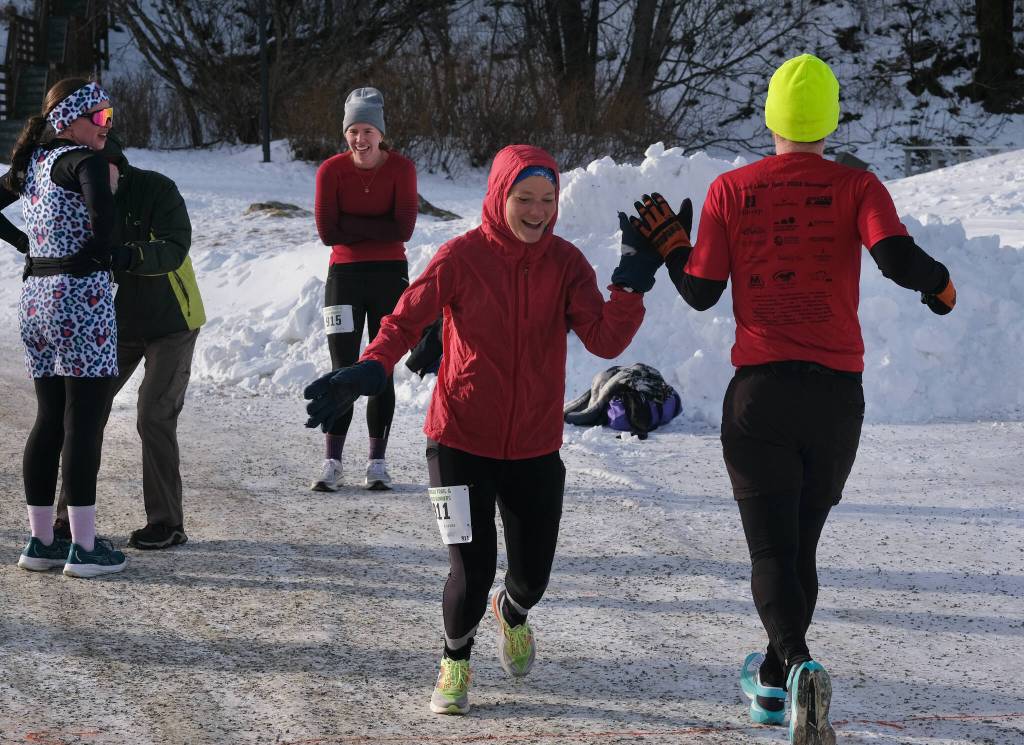 Heather Parker and Quinn Tracy tag during the Sweetheart Relay on Saturday at Sandy Beach. (Klas Stolpe / Juneau Empire)