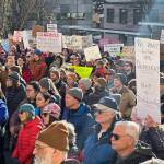 People wave signs expressing concerns about a wide range of issues during a No Kings on Presidents Day protest Monday at the Alaska State Capitol. (Mark Sabbatini / Juneau Empire)