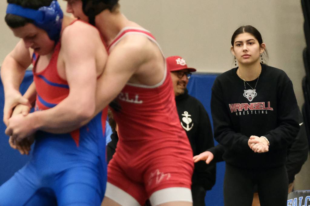 Wrangell senior Della Churchill mimics a wrestling grasp as she coaches a Stikine Wolves grappler during the Southeast Middle School Regional Wrestling Championships at Thunder Mountain Middle School last week. (Klas Stolpe / Juneau Empire)