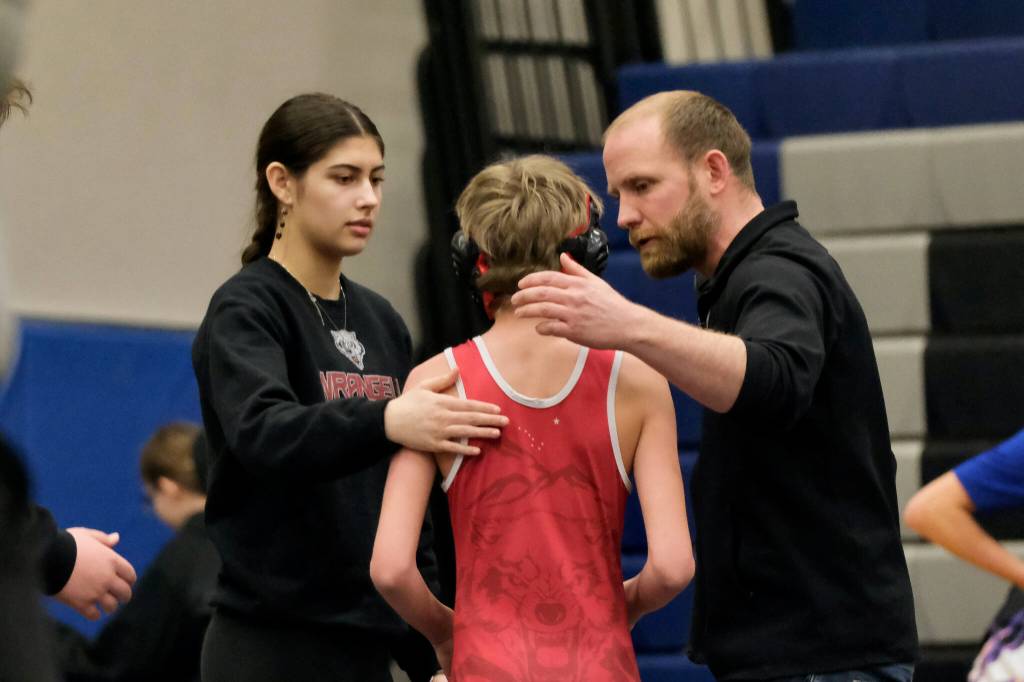 Wrangell senior Della Churchill and Stikine Middle School coach Jack Carney talk to Stikine Wolves grappler Radley Powers after his 85-pound match during the Southeast Middle School Regional Wrestling Tournament Saturday at Thunder Mountain Middle School in Juneau. (Klas Stolpe / Juneau Empire)