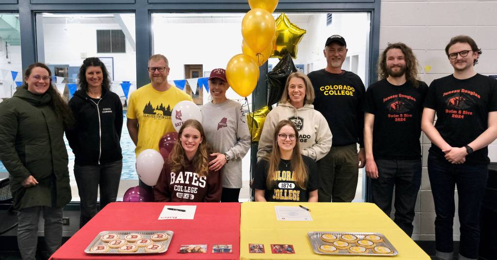 Juneau-Douglas High School: Yadaa.at Kalé coaches Amber Kelly, Corrine Bullick, Gastineau Swim Club coach Scott Griffith, JDHS senior Pacific Ricke and mother Kirsten Amann, JDHS senior Lucia Chapell and parents Sara and Richard, and JDHS coaches Noah and Josiah Loseby pose after Pacific and Lucias college signing Thursday at Augustus Brown Pool. (Klas Stolpe / Juneau Empire)