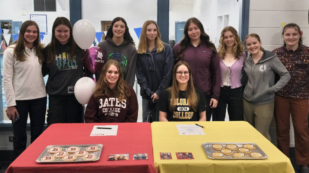 Juneau-Douglas High School: Yadaa.at Kalé senior swimmers Pacific Ricke and Lucia Chapell pose with friends and teammates after signing national letters of intent to become student-athletes at Bates College and Colorado College, respectively, Thursday at Augustus Brown Pool. (Klas Stolpe / Juneau Empire)