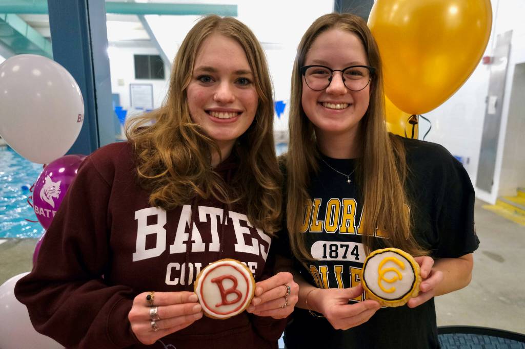 Juneau-Douglas High School: Yadaa.at Kalé senior swimmers Pacific Ricke and Lucia Chapell hold celebratory cookies after signing national letters of intent to become student-athletes at Colorado College and Bates College, respectively, Thursday at Augustus Brown Pool. (Klas Stolpe / Juneau Empire)