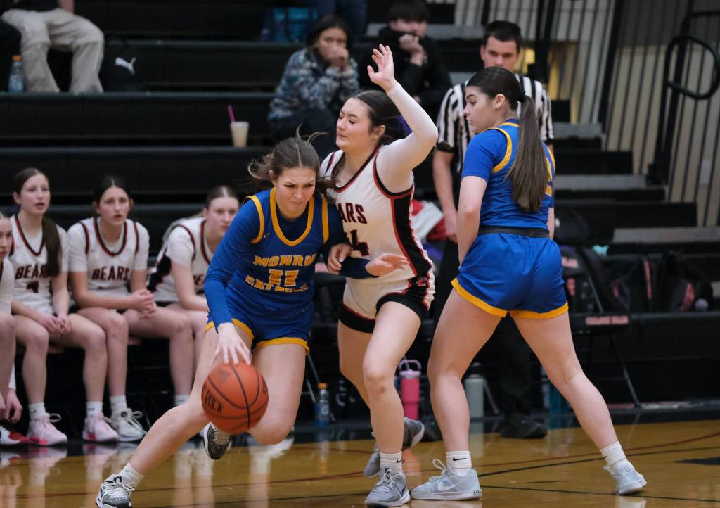 Juneau-Douglas High School: Yadaa.at Kalé sophomore Layla Tokuoka (14) fights through a screen by Monroe junior Trinity Turiel (32) while defending sophomore Leyton Cortez (11) during the Crimson Bears 52-40 win over the Rams on Friday in the George Houston Gymnasium. (Klas Stolpe / Juneau Empire)