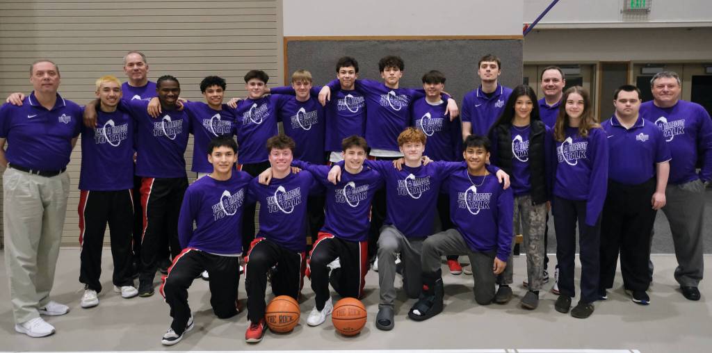 The Juneau-Douglas High School: Yadaa.at Kalé boys basketball team pose for a photo in their purple Take A Timeout To Talk warmup jerseys on Friday before their game against Monroe. (Klas Stolpe / Juneau Empire)