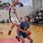 Juneau-Douglas High School: Yadaa.at Kalé senior Ben Sikes (11) defends Monroe senior Tucker Williams (22) during the Crimson Bears 76-55 loss to the Rams on Friday in the George Houston Gymnasium. (Klas Stolpe / Juneau Empire)