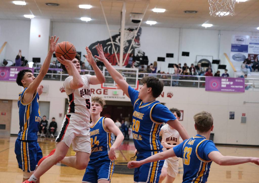 Juneau-Douglas High School: Yadaa.at Kalé junior Brandon Casperson (5) shoots against Monroe senior Jett McCullough (4), sophomore Zavier Oleson (24), junior James Trieglaff (20) and freshman Harry Roberts (33) during the Crimson Bears 76-55 loss to the Rams on Friday in the George Houston Gymnasium. (Klas Stolpe / Juneau Empire)