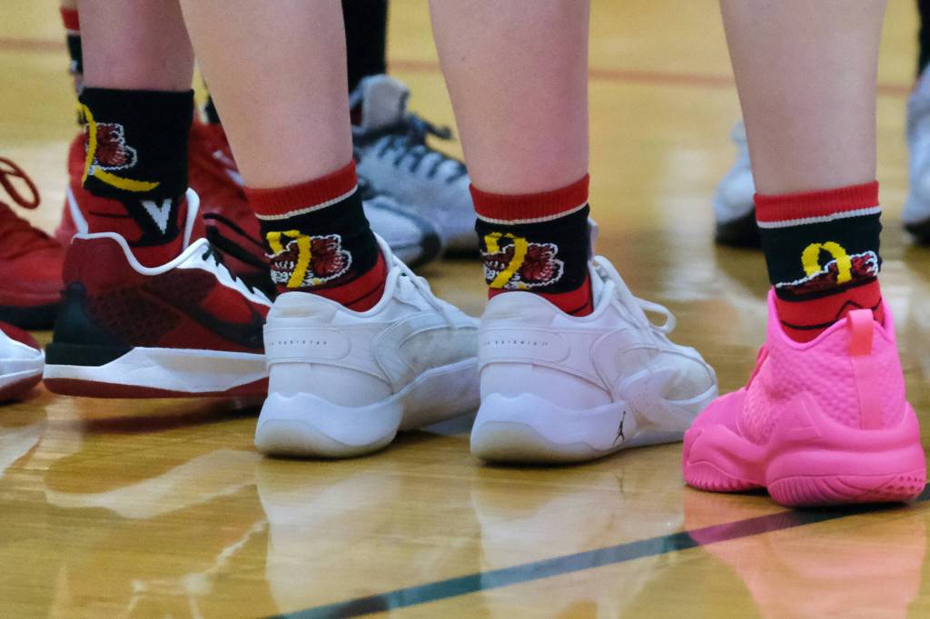 On Saturday all four varsity basketball teams from Juneau-Douglas High School: Yadaa.at Kalé and Monroe wore customized basketball socks with the special JDHS bear and childhood cancer logo as part of the Cancer Connection fundraiser. (Klas Stolpe / Juneau Empire)