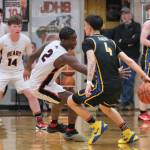 Juneau-Douglas High School: Yadaa.at Kalé senior Ahmir Parker (2) attempts a steal as Monroe senior Jett McCullough (4) dribbles behind his back during the Crimson Bears 71-55 loss to the Rams on Saturday in the George Houston Gymnasium. (Klas Stolpe / Juneau Empire)