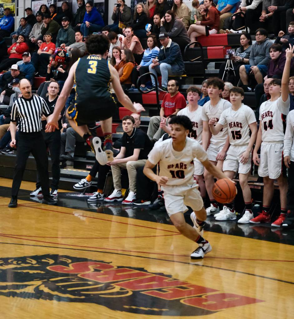 Juneau-Douglas High School: Yadaa.at Kalé senior Pedrin Saceda-Hurt (10) fakes Monroe sophomore defender Adam Geyer into the air during the Crimson Bears 71-55 loss to the Rams on Saturday in the George Houston Gymnasium. (Klas Stolpe / Juneau Empire)