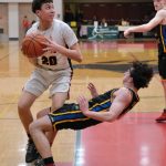 Juneau-Douglas High School: Yadaa.at Kalé junior Elias Dybdahl (20) sets for a shot as Monroe sophomore Adam Geyer attempts to take a charge during the Crimson Bears 71-55 loss to the Rams on Saturday in the George Houston Gymnasium. (Klas Stolpe / Juneau Empire)
