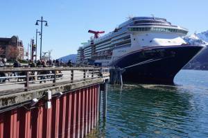 Tourists walk along Juneaus harbor on April 26, 2024, next to the docked Carnival Spirit, a ship operated by Carnival Cruise Line. Cruise ship visitation to Alaska has increased in recent years, and so have measured violations of wastewater standards. (Yereth Rosen/Alaska Beacon)