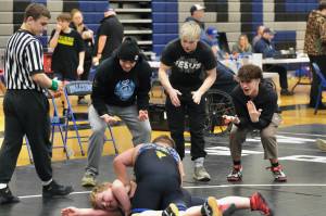 Juneau-Douglas High School: Yadaa.at Kalé sophomore Jed Davis officiates a match as sophomore Jaxin Jim, senior Colton Cummins and freshman Carson Cummins coach elementary school age wrestlers. (Klas Stolpe / Juneau Empire)